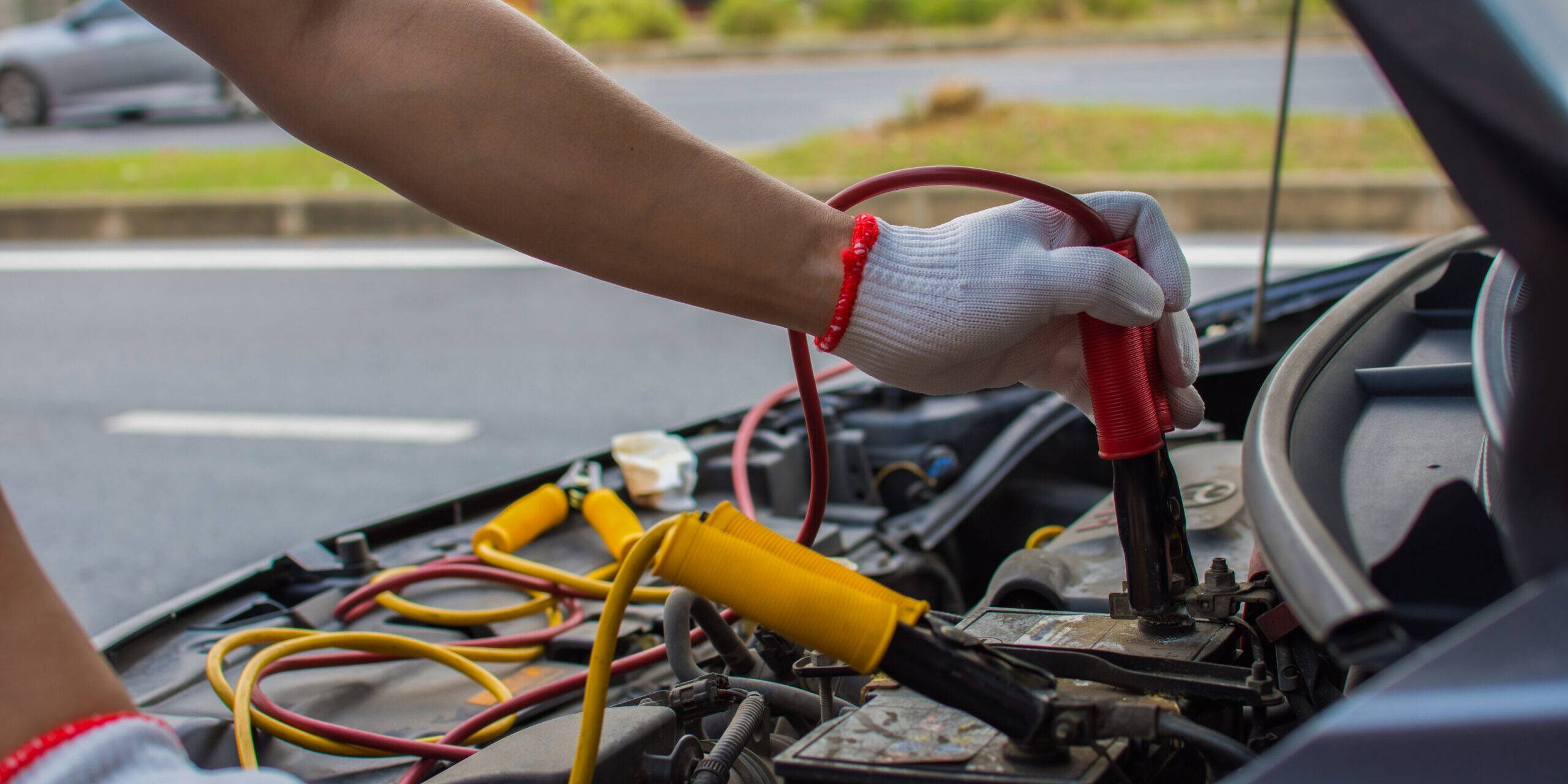 The Technician Uses A Booster Cable To Connect The Dead Battery. Electric Vehicle Battery Charging Via Jumper Cable The Technician Uses A Booster Cable To Connect The Dead Battery. Electric Vehicle Battery Charging Via Jumper Cable