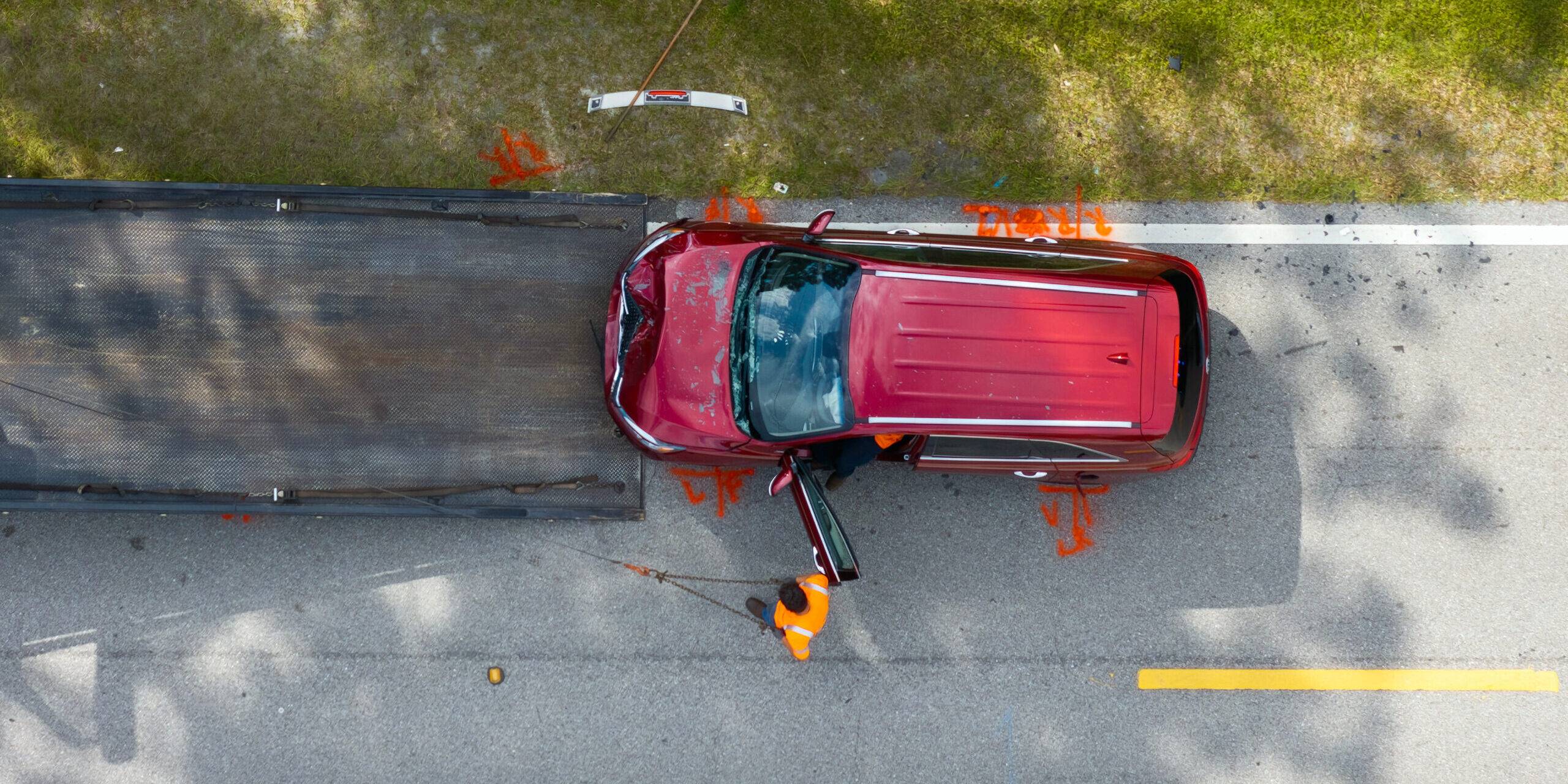 Car Crash Site With Tow Truck Loading Destroyed Vehicle On American Street. Emergency Services Personnel Responding To Accident In Florida, Usa Car Crash Site With Tow Truck Loading Destroyed Vehicle On American Street. Emergency Services Personnel Responding To Accident In Florida, Usa